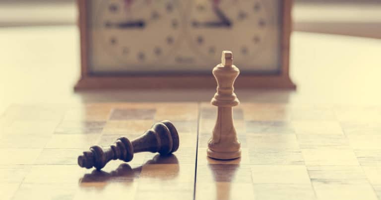 Schachbrett mit um geworfenen König und Schachuhr im Hintergrund - bildlich für Gewerblicher Rechtsschutz